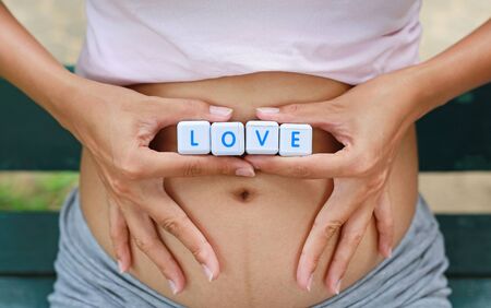 Woman holding character cubic LOVE at her belly.の写真素材