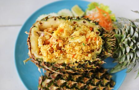 Prepared pineapple fried rice served inside of a pineapple carved like a bowl. Top view.の写真素材