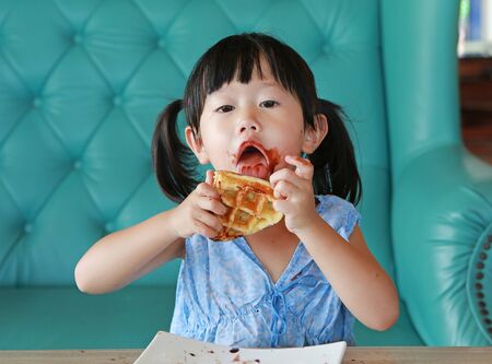 Portrait child girl eating ice cream wafflesの写真素材