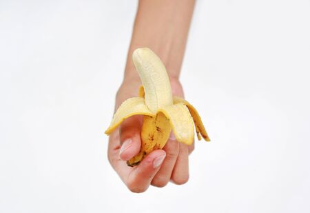 Hand holding peel banana on white backgroundの写真素材