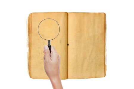 Hand holding Magnifying glass on old book against white backgroundの写真素材