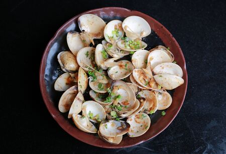 Fried Clams with spicy in plate on black table, Top view.