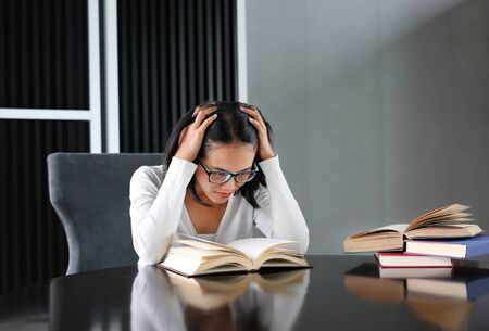 Asian woman reading a book in the library.