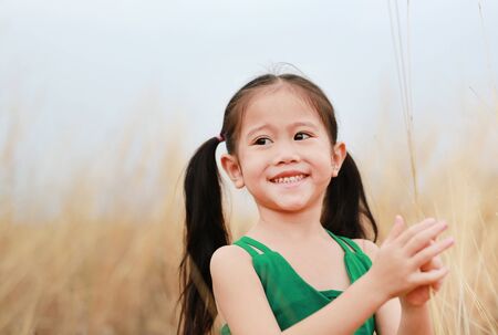 Free happy child girl in dried grass field with smiling.の写真素材
