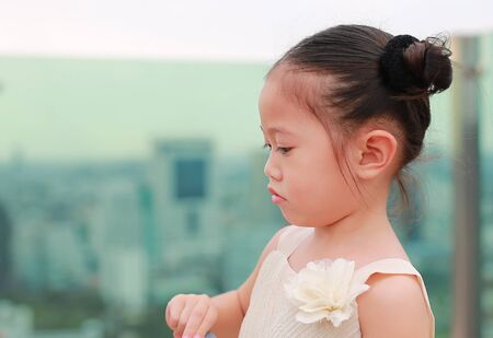 Close up Cute little child girl in dress at the rooftop of building.の写真素材