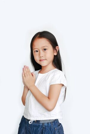Beautiful little Asian child girl praying isolated on white background (Sawasdee is meaning hello).の写真素材