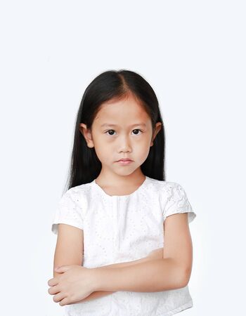 Cute little hispanic Asian child girl with arms crossed and angry about something over white background with looking at camera. Person with Negative emotion concept.の写真素材