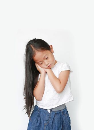 Closed eyes caucasian little child girl sleep gesture posing with hands togethe isolated over white background.の写真素材