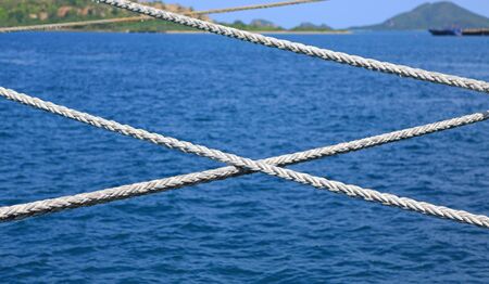 Ship rope against blue water sea texture background.