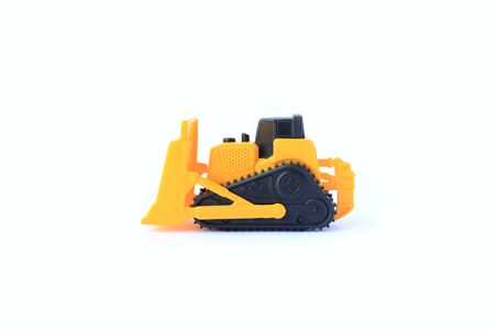 The yellow toy car Bulldozer isolated on white background. Children's tractor toy. Wheel loader construction car model.の写真素材