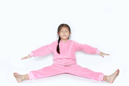 Portrait of smiling little Asian kid girl in pink tracksuit or sport cloth doing exercises isolated on white background.の写真素材