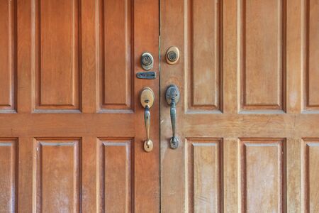 Close up brown wooden door with key lock and handle.の写真素材