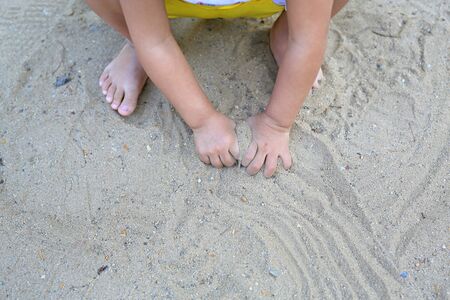 Close up hands of baby playing in garden with soil.の写真素材