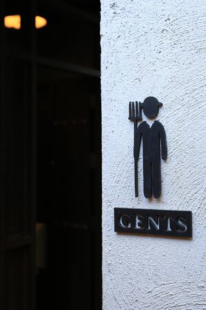 Toilet male signs on the abstract white rough cement wall backgroundの写真素材