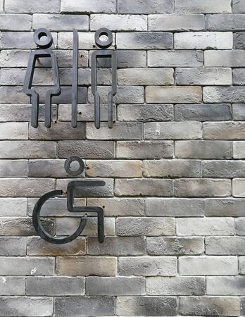 Toilet signs on modern grey brick wall background.の写真素材