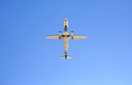 Commercial jet airplane flight on blue sky background. Seen from below.の写真素材