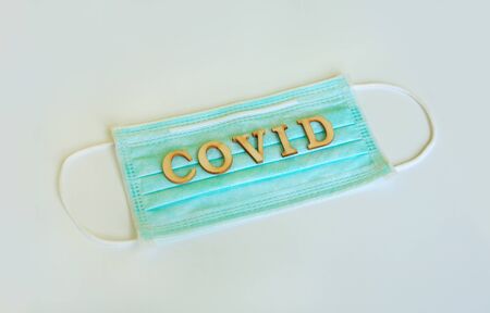 Medical shielding mask with word COVID isolated over white background.の写真素材