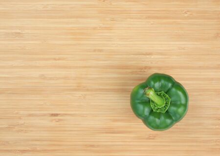 Green bell pepper on wooden board background with copy spaceの写真素材
