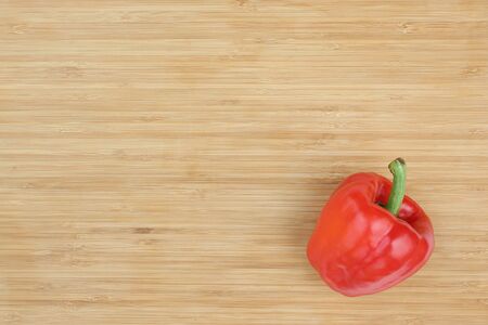 Red bell pepper on wooden board background with copy space