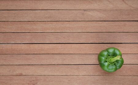 Green bell pepper on wooden plank background with copy spaceの写真素材