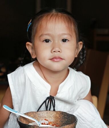 Close up asian kid girl eating rice delicious japanese food on table for lunch in the restaurantの写真素材