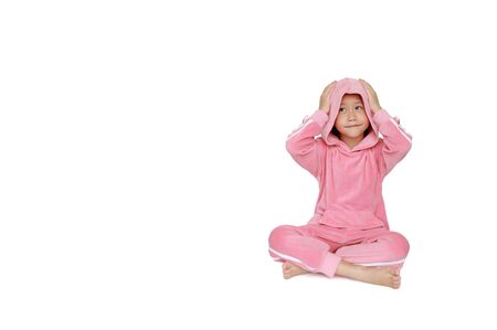 Smiling little Asian child girl in pink tracksuit or sport cloth with hood on head looking up isolated on white background with copy space.の写真素材