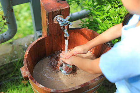 Close-up asian little child girl washing hands in water sinks.の写真素材