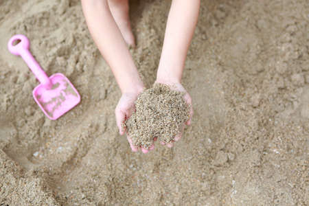 Close up hands of child holding of sand.の写真素材
