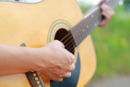 Playing acoustic guitar in the nature at the morning.