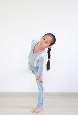 Portrait of asian little girl standing posture in room against white wall background.の写真素材