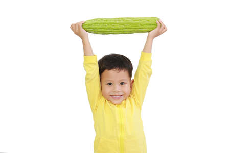 Strong Asian baby boy raised Bitter gourd over his head isolated on white background with clipping pathの写真素材