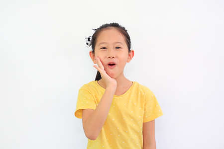 Portrait of smiling Asian little child girl isolated on white background. Kid looking at camera and hand touching on cheekの写真素材