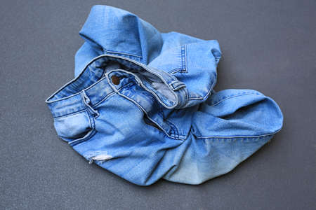 Crumpled blue jeans on gray tile floor backgroundの写真素材
