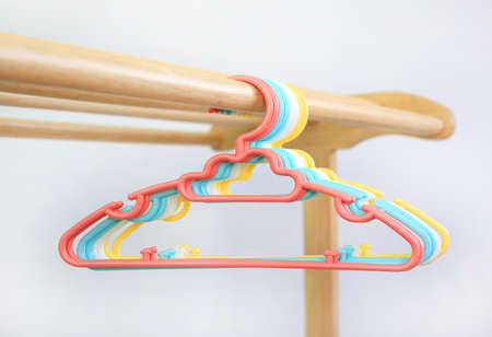 Colored plastic Clothes Hangers on wooden clothes line against white backgroundの写真素材