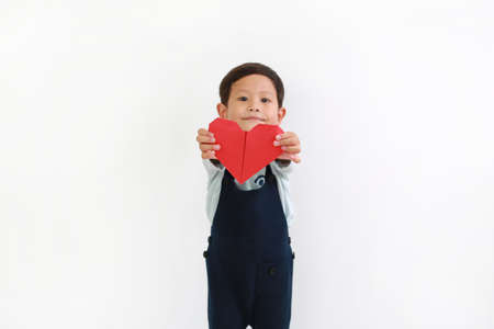 Portrait of Asian little baby boy giving red heart sign for you against white background. Focus at red heart in handsの写真素材