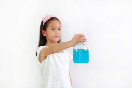 Asian girl kid using bottle spray alcohol liquidの写真素材