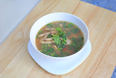 Chicken Foot with hot and sour soup in bowl on wood table background. Thai food.