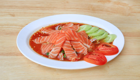 Salmon spicy salad in dish on wood table background.