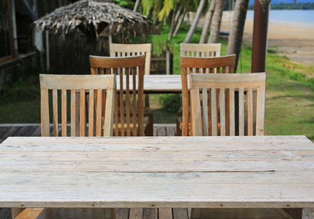 Empty wood table and chairs at restaurants near the beach.