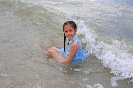 Asian young girl enjoy playing and lying on tropical sea beach.の写真素材