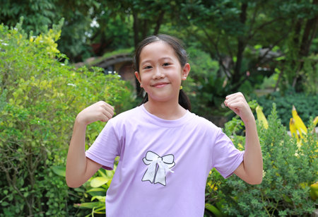 Attractive Asian girl show muscles and strength while exercise outside in the garden.の写真素材