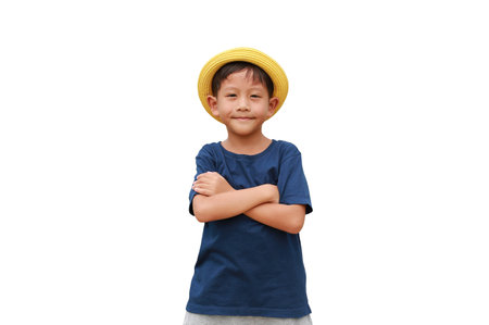 Portrait of Asian little boy child wearing a yellow straw hat standing and crossing arms isolated on white background.の写真素材