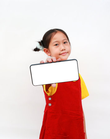 Asian girl child showing blank white screen of smartphone and looking camera over white background.の写真素材