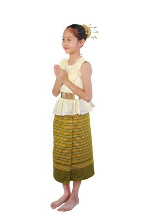 Asian girl child in traditional Thai dress sarong with Pay respect, Sawasdee symbol, Welcome gesture isolated on white background. Image full length with clipping path.の写真素材