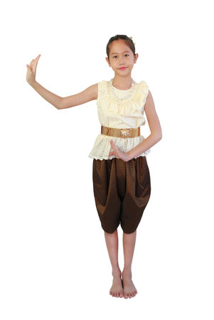 Beautiful Asian young girl child wearing traditional Thai style dress with native dancing gesture isolated on white background. Image full length with clipping path.の写真素材