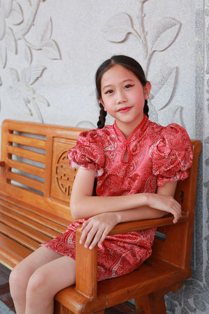 Portrait of beautiful Asian girl child in traditional dress celebrates Chinese new year.の写真素材