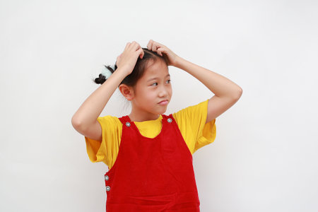 Shy Asian girl child make gesture scratching head on white background.の写真素材