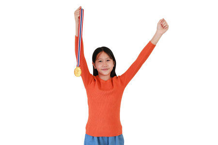 Cheerful Asian girl kid show gold medal on white studio background. Child celebrating victory posture concept.の写真素材