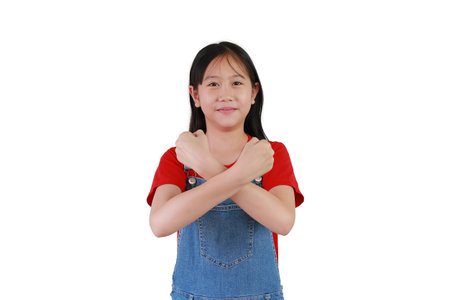Happy kid show arms x sign and looking camera. Portrait of Asian pretty girl crossed hands posture on chest isolated on white background.の写真素材
