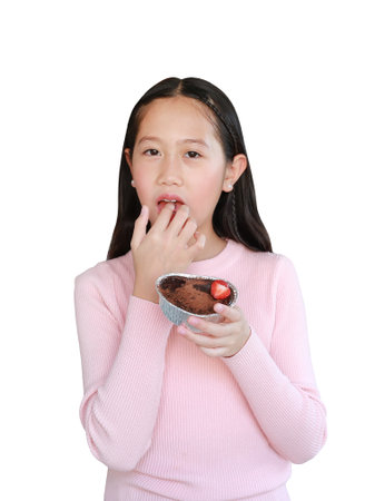 Portrait of Asian girl child eating chocolate cake by index finger isolated on white background. Image with clipping path.の写真素材